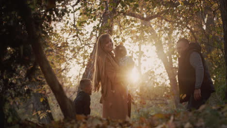 family have fun in autumn park, throw up leaves, have a good time together