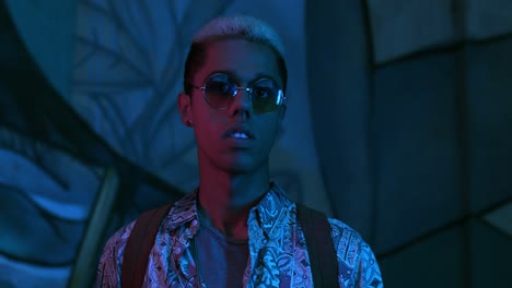 stylish young african american man in sunglasses smiling at the camera outdoors at night