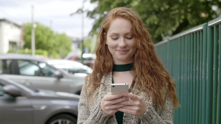 Girl going down the street and using a mobile phone