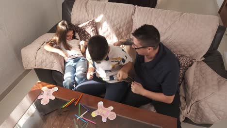 mother playing with her kids in the sofa at home