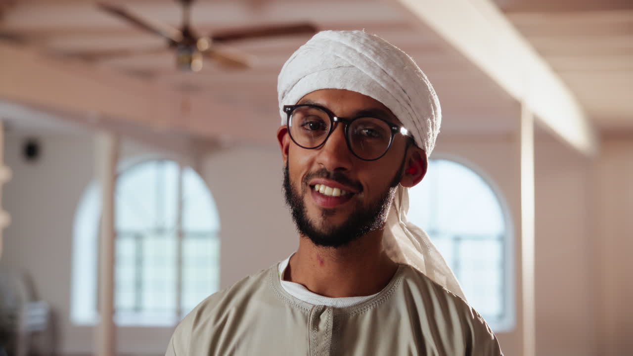 Portrait of a smiling Muslim man wearing a turban and glasses