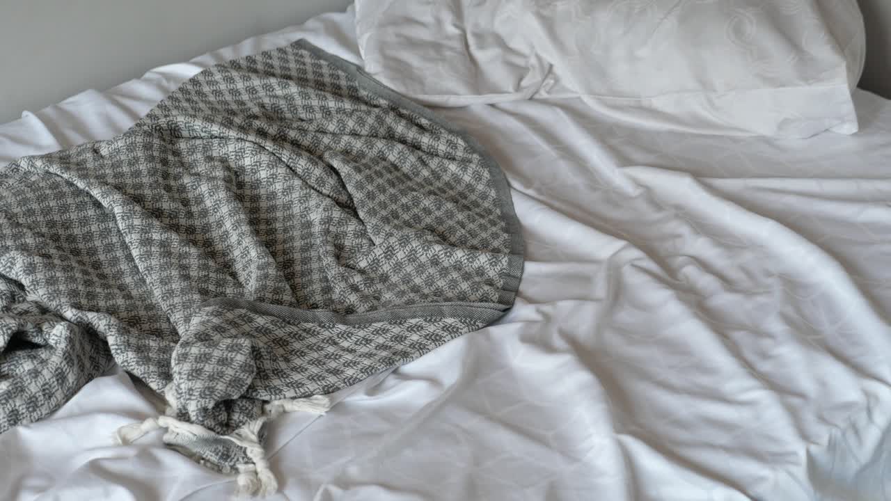 белая кровать с серым одеялом