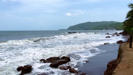 sea waves hitting rocks on a sunny day cola beach goa india 4k