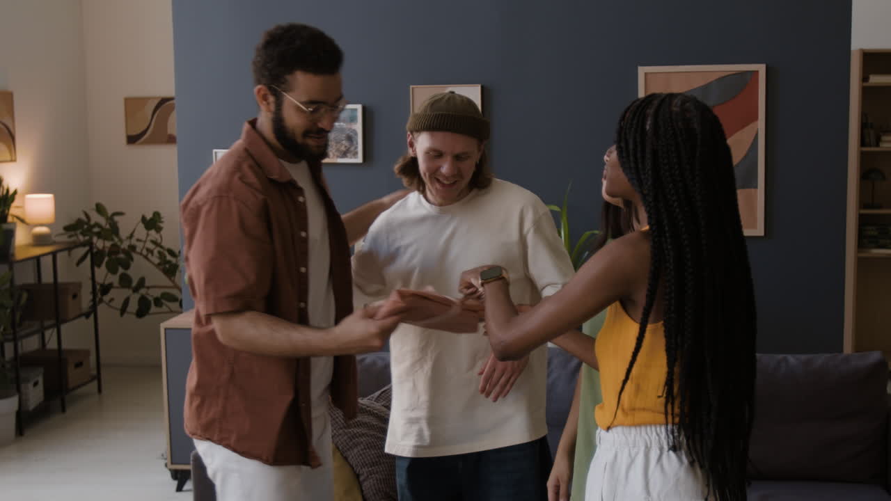 Friends Exchange a Gift and Share a Hug in a Living Room
