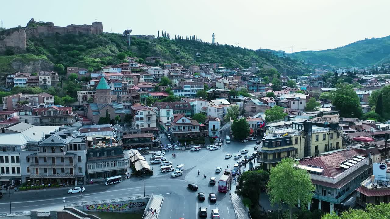 drone disparar para la vieja tbilisi con la naturaleza y los edificios antiguos y la iglesia con la calle llena de coches y la naturaleza verde