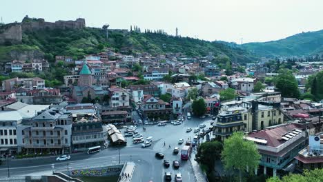 drone shoot for old tbilisi with nature and old buildings and church with street full of cars and green nature