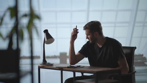un hombre serio se sienta en una computadora en la oficina y piensa. analiza resuelve un problema de crisis. una etapa difícil en los negocios. hombre de negocios reflexivo