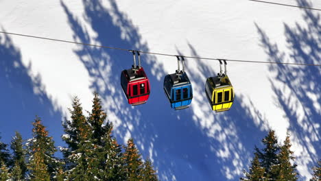 cable cars moving to the top of a mountain in wintertime