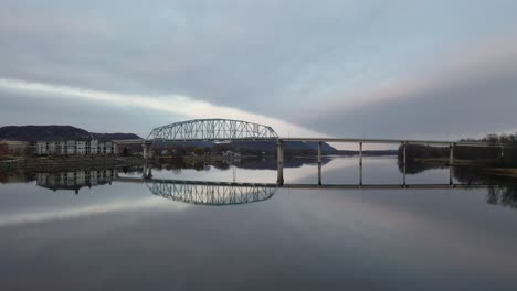 reflejo pacífico de un puente sobre un río al amanecer o al anochecer