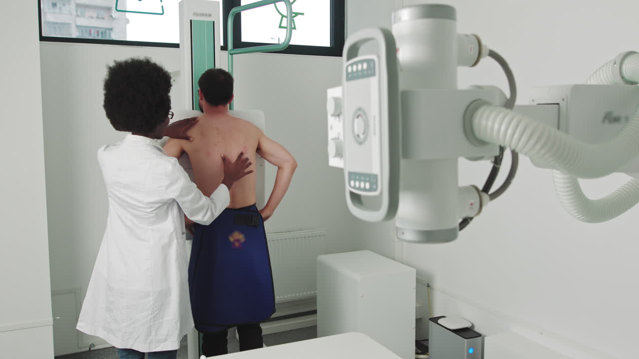 Female african doctor helps patient in medical office in the hospital man standing face against the