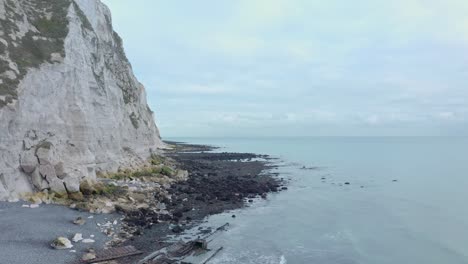 Descending-crane-shot-of-shipwreck-on-white-cliffs-of-dover-beach