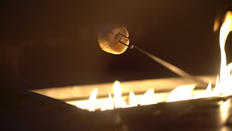 sabroso malvavisco blanco en brocheta asada sobre fogata de gas