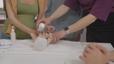 teacher in class with two pregnant woman and toy baby