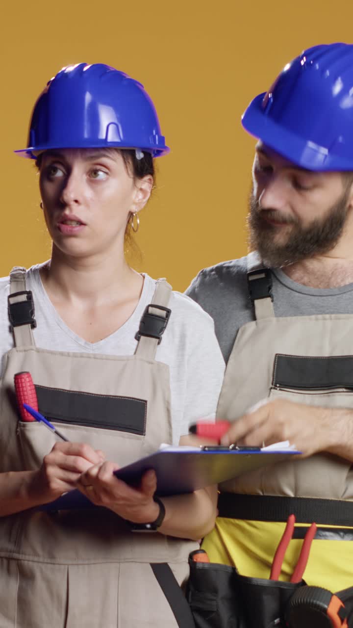 Vertical video: Construction workers calculating measurement on papers