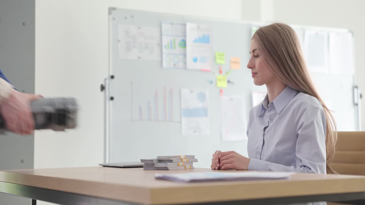 Business transaction and handshake involving money in an office