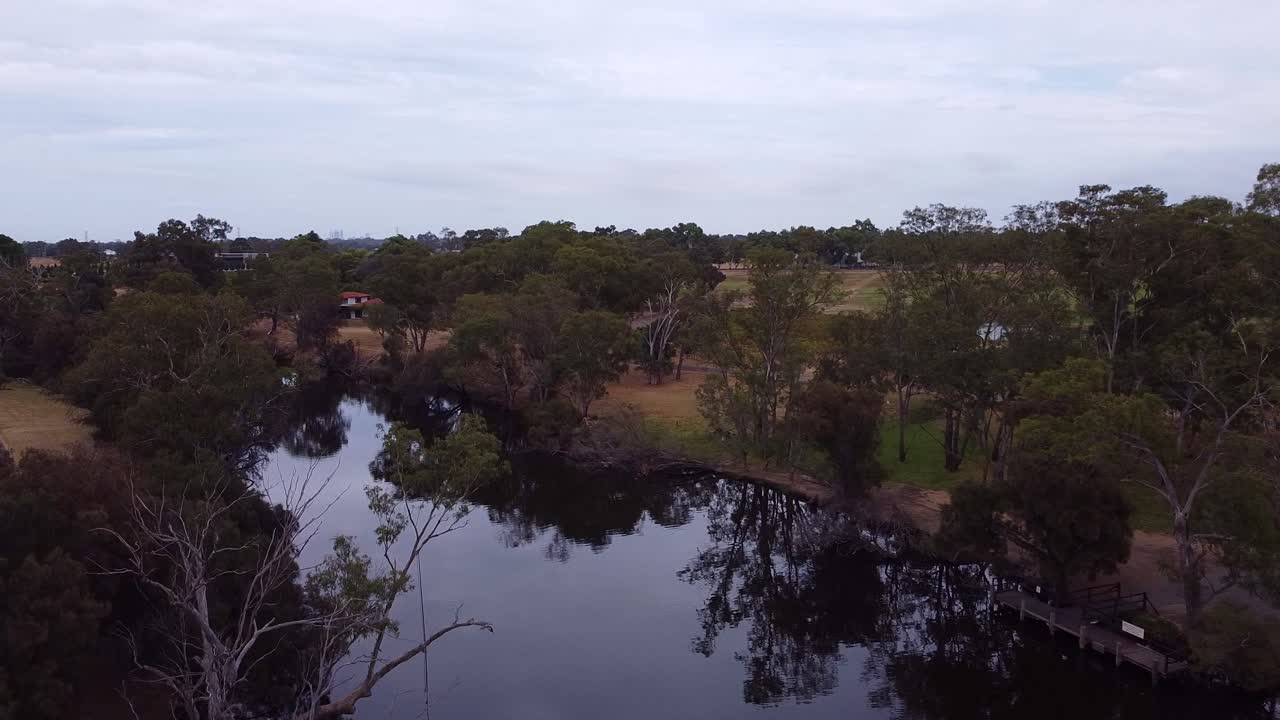 나무들은 높이 서 있고 강에서 반영되어 하루가 끝나고 있습니다.