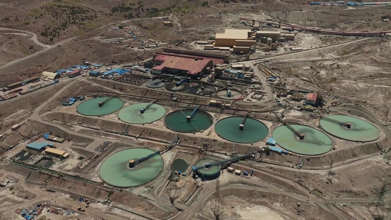 Elegant drone pan moving across large circular tailings thickeners at a copper processing facility. The footage showcases industrial design, sustainable water management, and the operational scale of