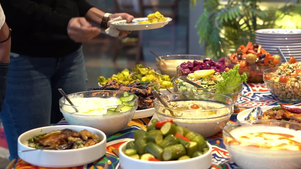 people pick their food in open buffet, close up shot