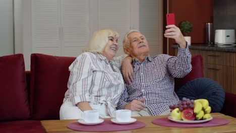 Senior-family-having-fun,-making-selfie-photos,-recording-video-together-on-smartphone-at-home