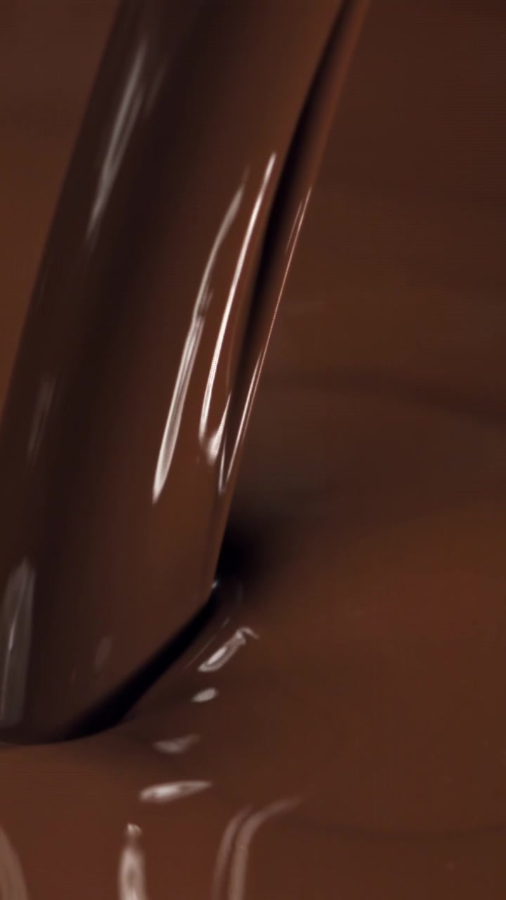 Primo piano al rallentatore di cioccolato liquido denso che si versa