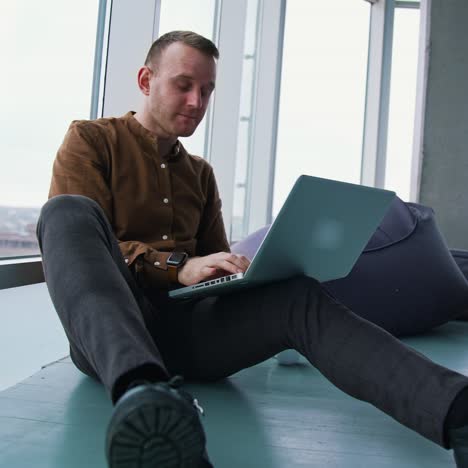 young man sitting on a floor with laptop computer. work stress concept of man