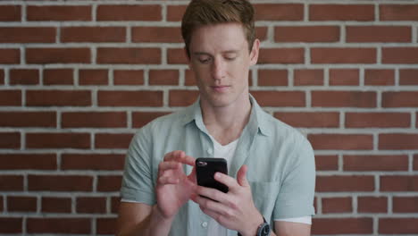 Retrato-Apuesto-Joven-Estudiante-Usando-Un-Teléfono-Inteligente-Navegando-Disfrutando-Leyendo-Mensajes-SMS-En-Línea-Sonriendo-Cabeza-Roja-Hombre-En-Teléfono-Móvil-Cámara-Lenta