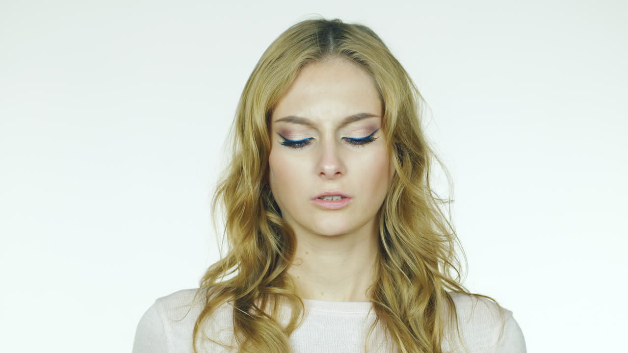 흰색 배경에 있는 스튜디오 비디오 그 여자는 두통이 있고 고통이 사라진다 그녀는 웃는다