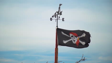 schwarze piratenflagge mit totenkopf und knochen, die in zeitlupe weht