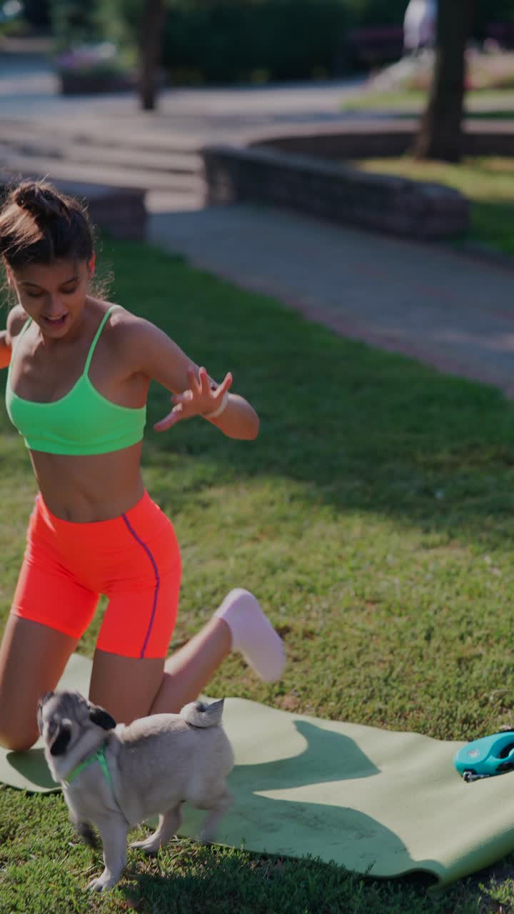 mujer jugando con su pug en el parque