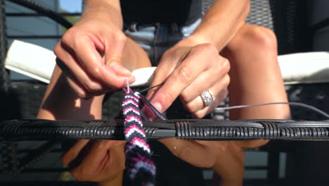 mujer trabajando en trenzar un brazalete de amistad, primer plano