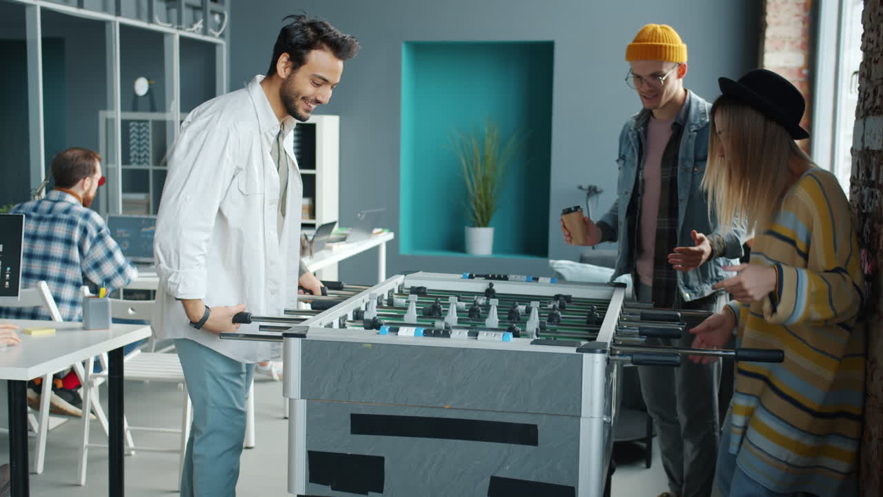 Coworkers Enjoying Foosball in Modern Office