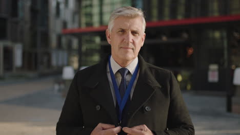 portrait of confident mature businessman smiling at camera confident in urban city at sunset