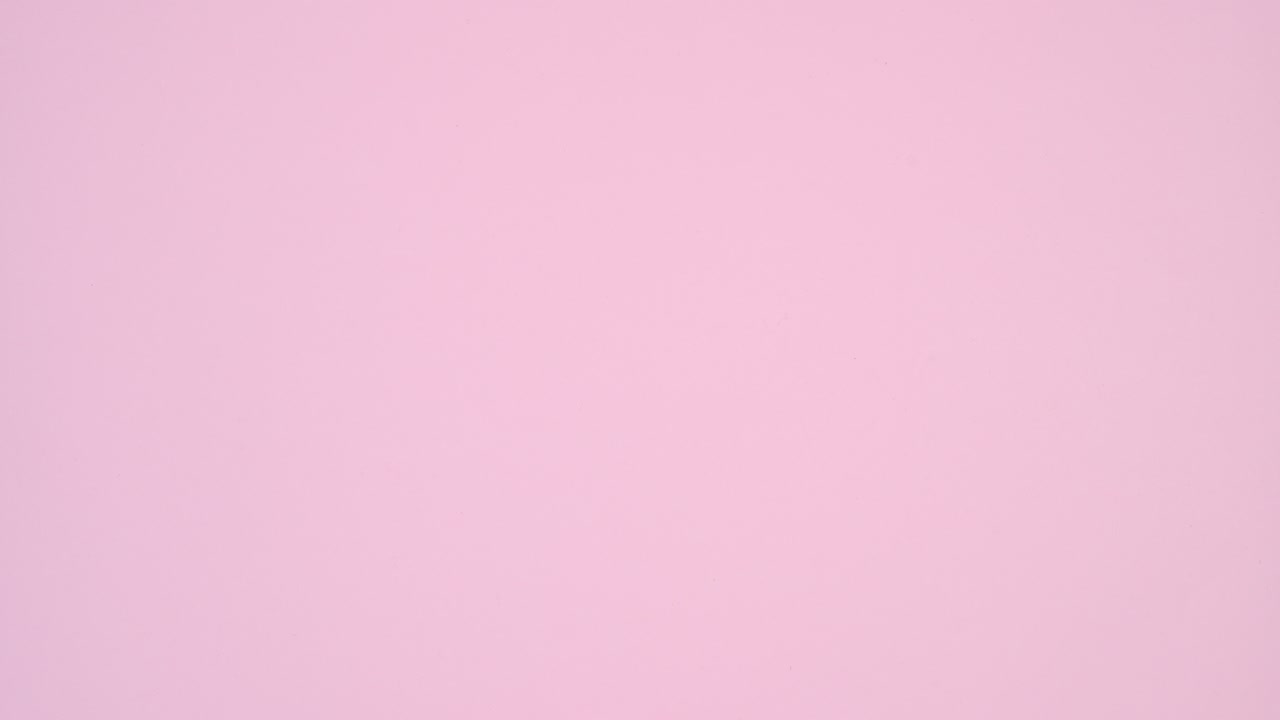 Red ribbon make heart on left side of pastel pink theme. Stop motion