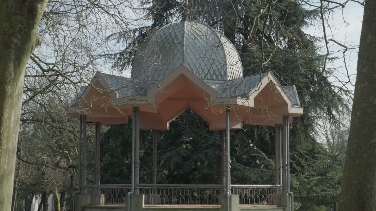 Elegante gazebo storico con tetto e colonne decorative situato in un ambiente di parco invernale circondato da alberi spogli ad Aviles, Asturie, Spagna