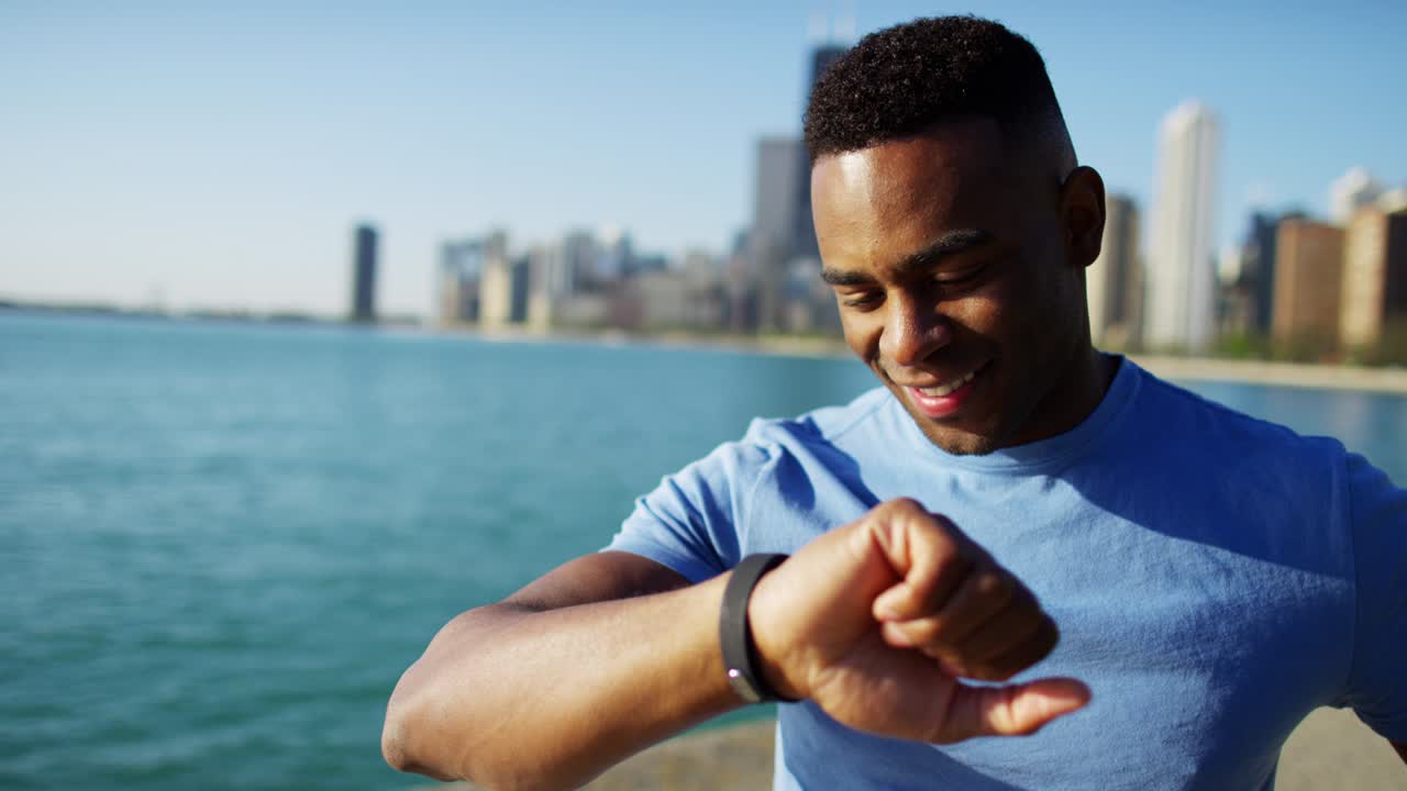 Ethnic male resting and checking pulse after workout