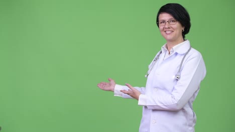 hermosa mujer médico con el cabello corto mostrando algo