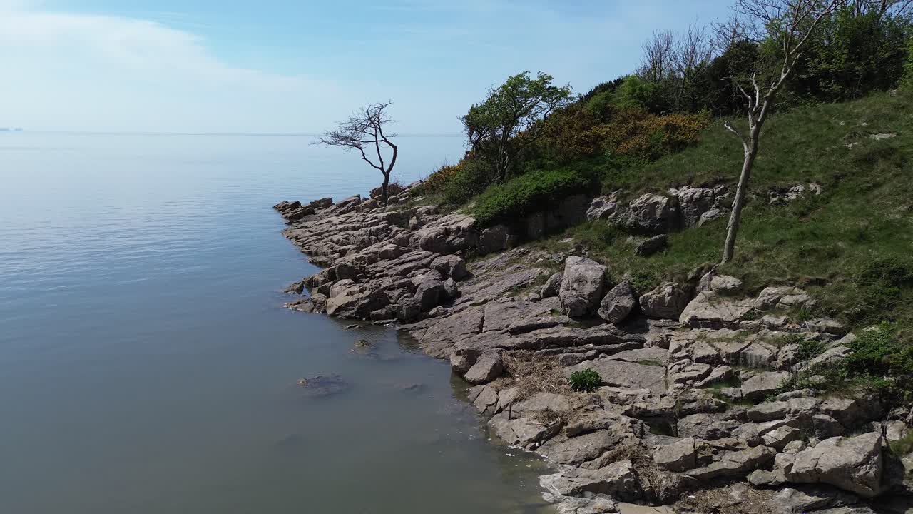 Rocky private shoreline aerial view rising over calming dreamlike fantasy bay seascape
