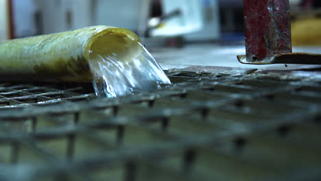 close-up, water discharged from the plastic pipe and flowing into the drain