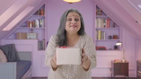 una anciana india feliz dando un regalo