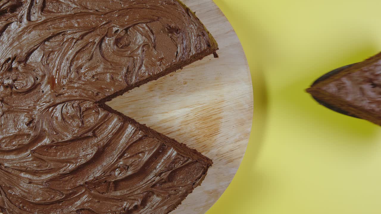 primer plano: mano masculina recoge un pedazo de pastel de chocolate - vista de arriba