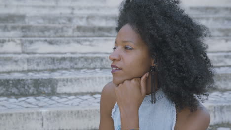 Side-view-of-pretty-woman-sitting-outside,-looking-aside