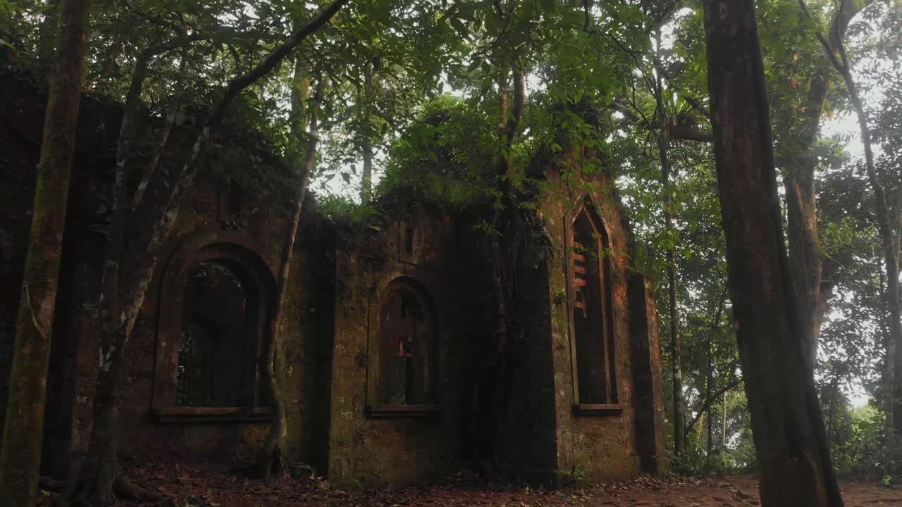 Vista aerea di inquietanti rovine di una chiesa abbandonata nel parco nazionale di Ba Vi, vicino ad Hanoi, Vietnam, con uno sfondo verdeggiante.