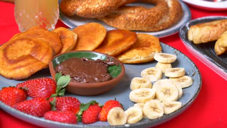 delicioso desayuno turco con panqueques, fresas, plátanos y chocolate