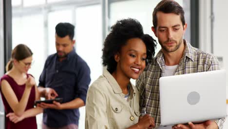 Business-executives-discussing-over-laptop