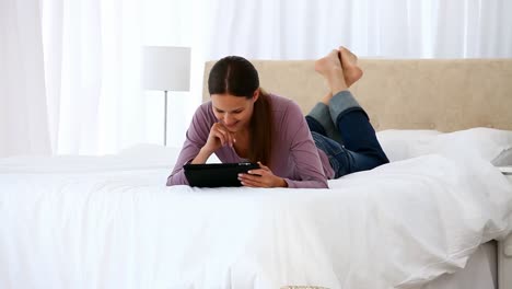 Hermosa-Mujer-Usando-Una-Tableta-De-Computadora-Acostada-En-La-Cama