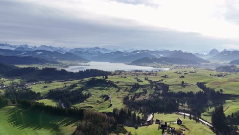 Scenic-aerial-view-of-village-and-artificial-mountain-lake-during-golden-hour