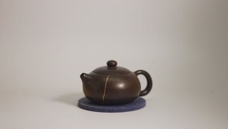 small brown teapot with golden crack repair