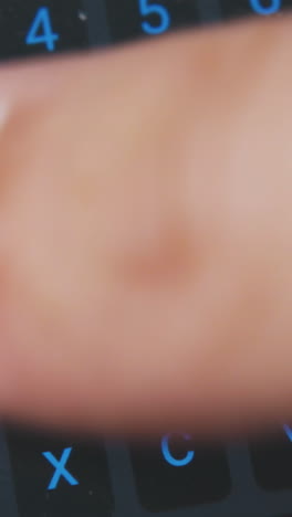 young man uses modern cell phone for texting message with keyboard on screen extreme close view