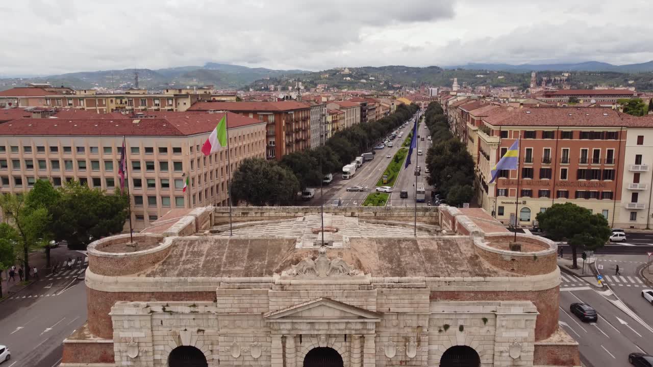Historical heritage building with flags and cityscape of Verona, aerial view