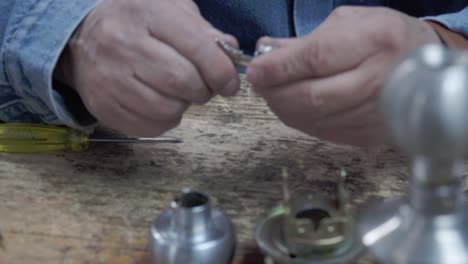 an expert in key duplication, examines a piece for lock repair and maintenance